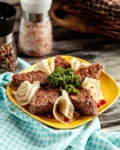 Creative lunch meat and bread dish with garnish on a yellow plate.