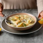 A creamy bowl of langostino mushroom sour cream gravy served with garlic bread, perfect for pasta or mashed potatoes.