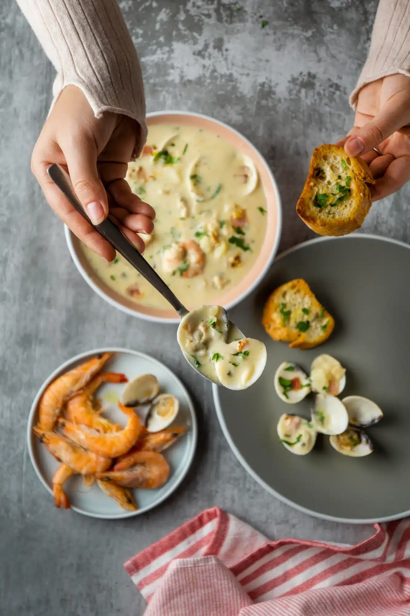 A serving of langostino sauce with garlic bread, clams, and shrimp, showcasing a creamy and flavorful seafood dish.