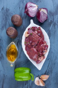 Raw beef kidneys with onions, green pepper, garlic, and olive oil, perfect for a French rognon recipe.