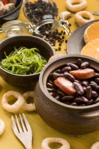 Black beans with smoked sausage in a rustic bowl alongside fresh greens and spices