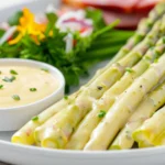 White asparagus with Hollandaise sauce served with a fresh salad, showcasing traditional German asparagus recipes.