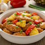 Sweet Hawaiian Crockpot Chicken with pineapple chunks and bell peppers in a white bowl.