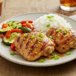 Grilled honey garlic chicken thighs served with rice and sautéed vegetables