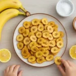 Plate of banana chips with kid’s hand reaching