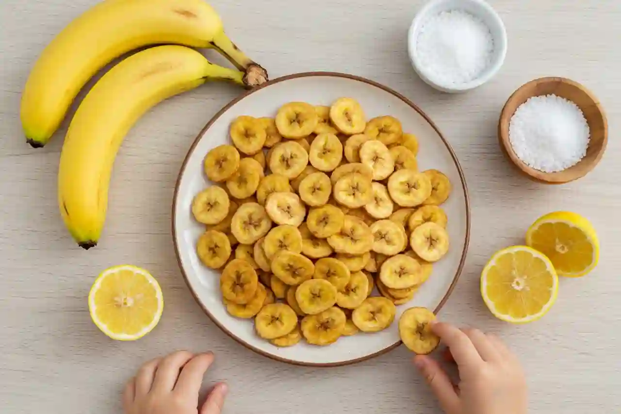 Plate of banana chips with kid’s hand reaching