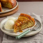 Slice of caramel apple upside down cake with caramel drizzle and ice cream