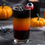 Layered Halloween cocktail with black, orange, and red colors