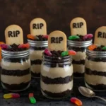 Graveyard pudding cups with tombstone cookies and gummy worms