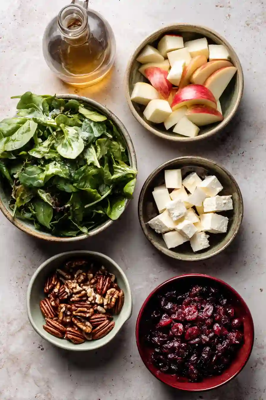 honeycrisp-apple-feta-salad-ingredients Flatlay of Honeycrisp Apple Feta Salad ingredients in ceramic bowls.