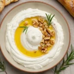 Bowl of spicy ricotta dip with hot honey, walnuts, and rosemary
